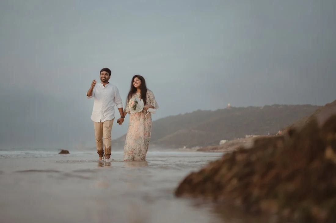 A couple walking beside the shoreline