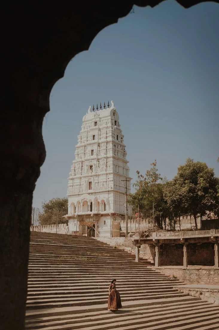 A temple tower and steps framed by a dark archway