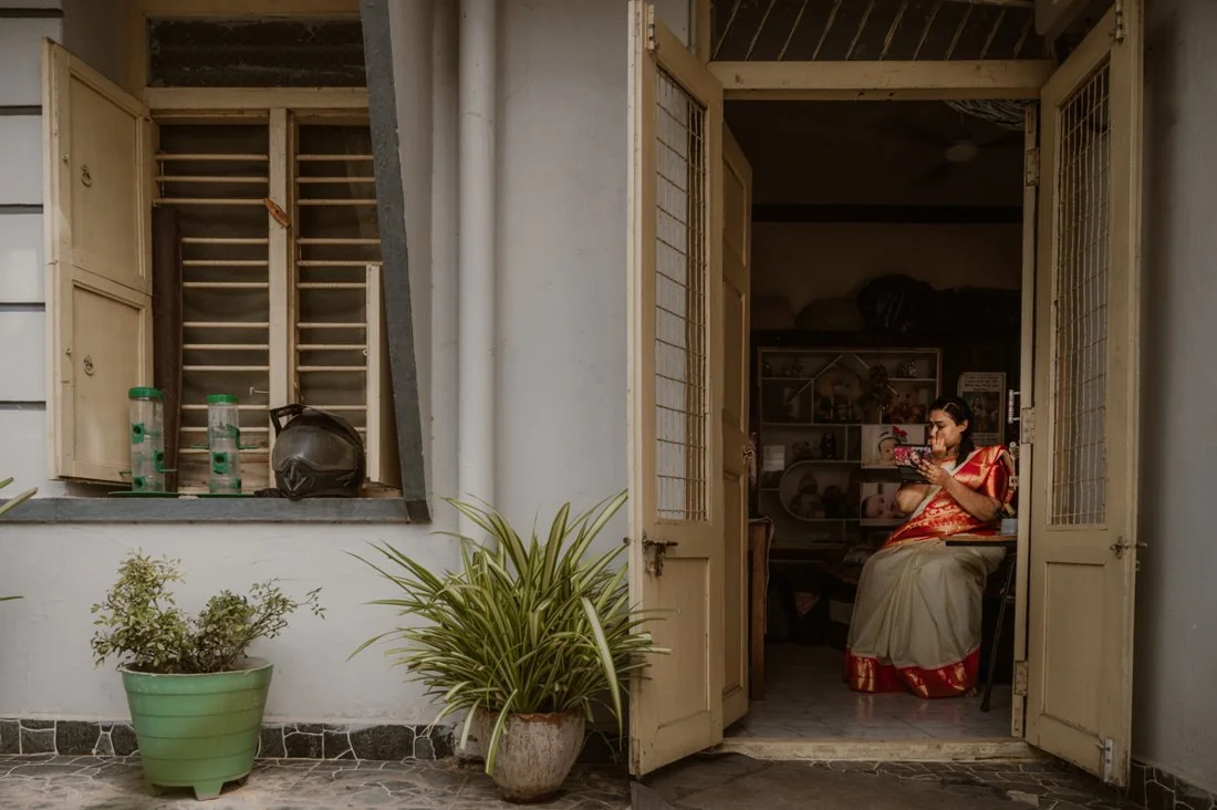 A woman seated in the doorway of a home