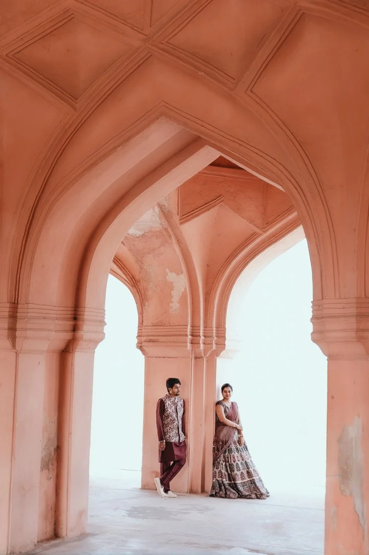 A couple beneath a tall stone archway